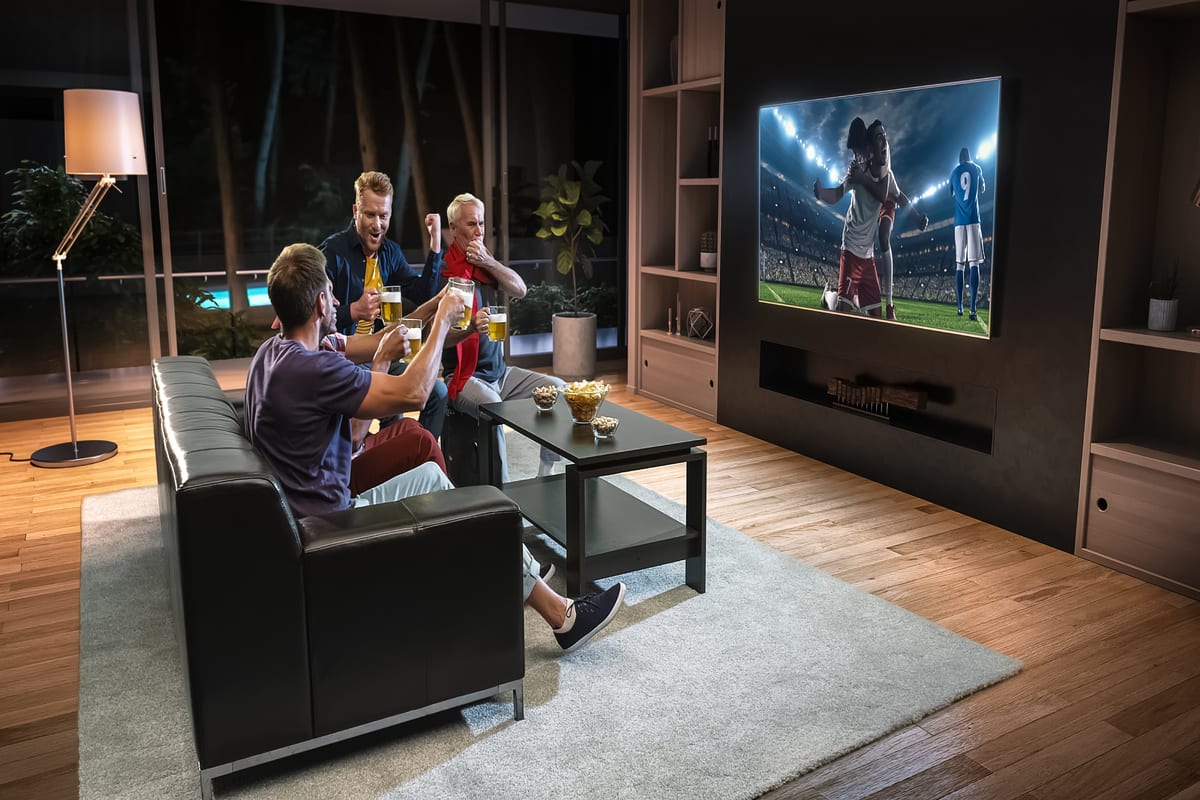 Group of fans are watching a soccer moment on the TV and celebrating a goal, sitting on the couch in the living room. The living room is made in 3D.