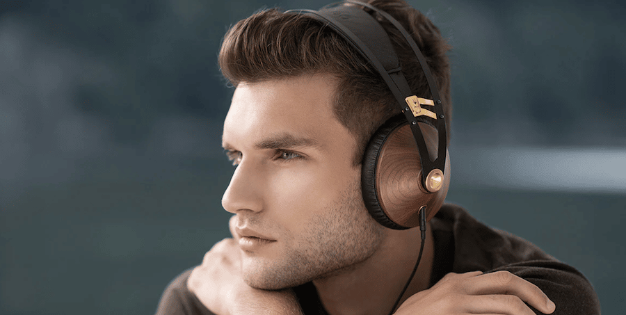 Man wearing high-end Meze Audio headphones plugged into his smartphone.