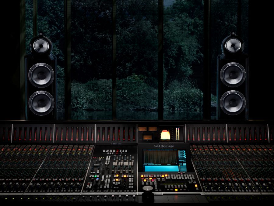 A mixing console with two high-end speakers on the sides.