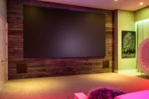 A home theater with a high-end surround sound system and rainbow colored lights. 