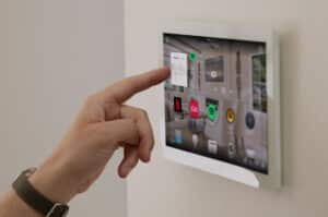 Hand tapping a touchscreen with the Control4 home automation interface.