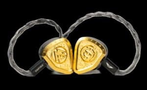 A close-up view of Empire Ears high-end in-ear monitors with gold trim and braided cable.