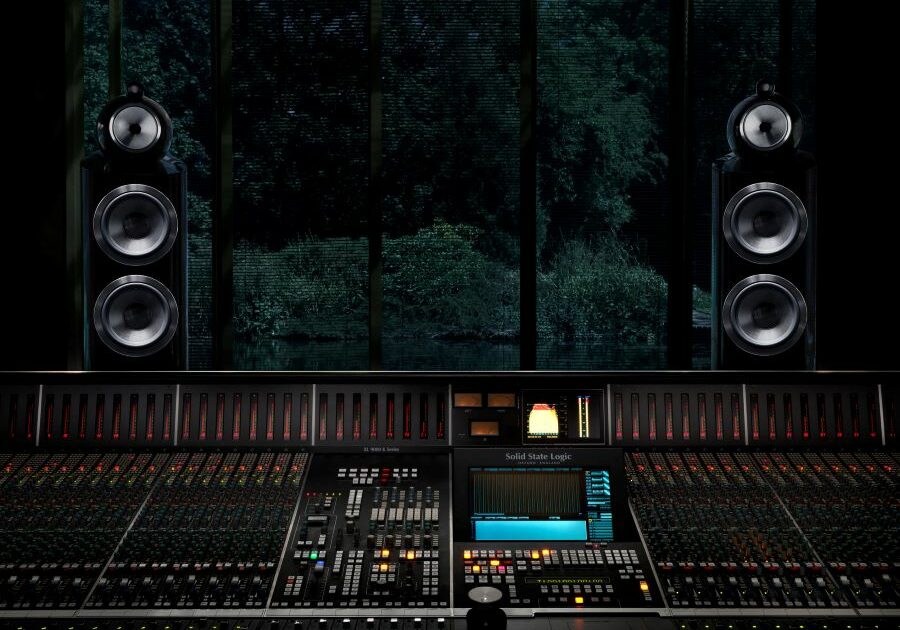 A mixing console with two high-end speakers on the sides.
