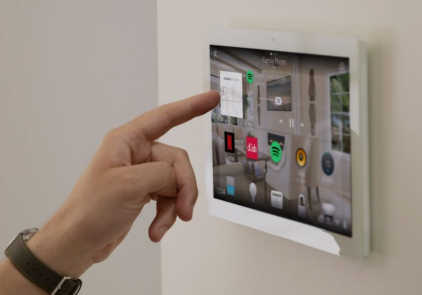 Hand tapping a touchscreen with the Control4 home automation interface.