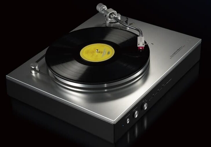 A sleek Luxman Audio turntable playing a vinyl record.