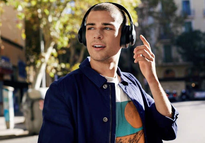 A man on a street in a city wearing headphones.
