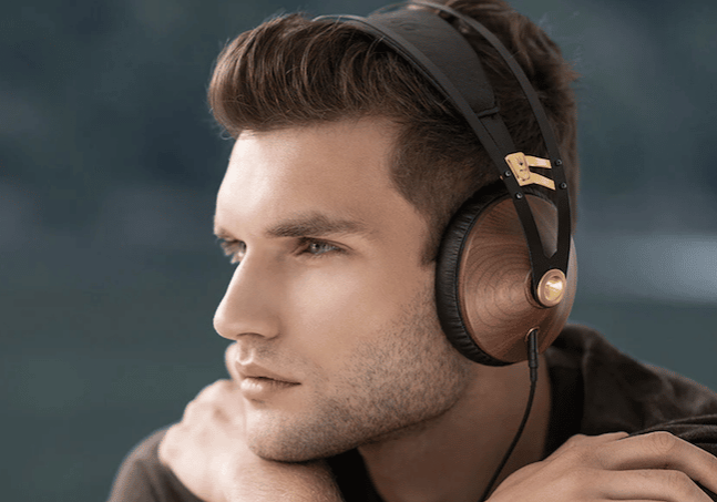 Man wearing high-end Meze Audio headphones plugged into his smartphone.