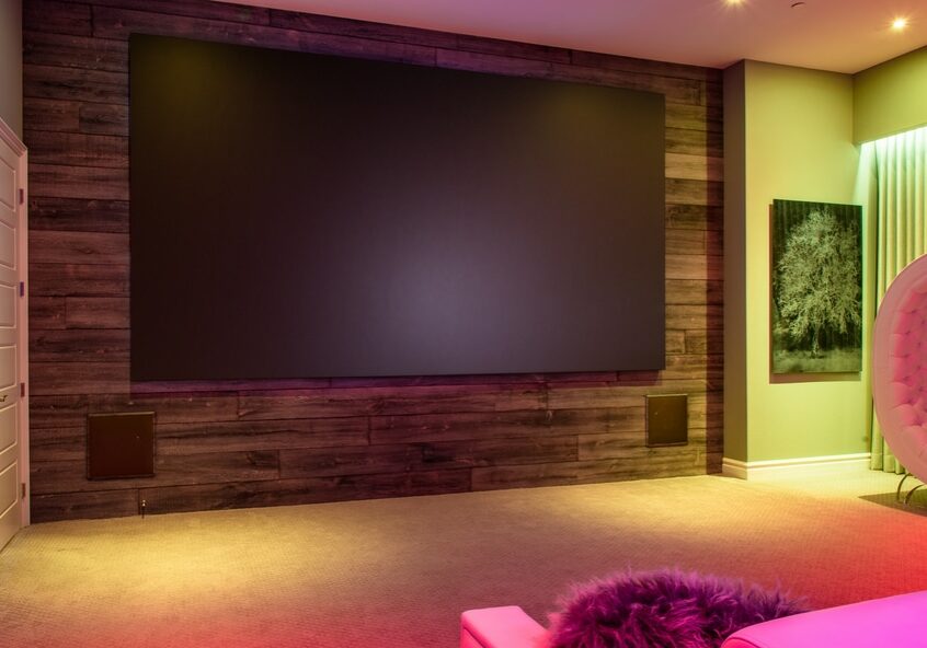 A home theater with a high-end surround sound system and rainbow colored lights.